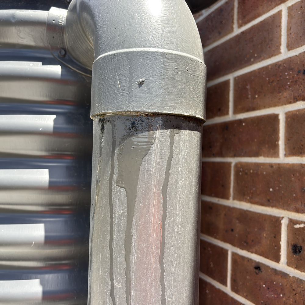 Rainwater tank overflow pipe dented and leaking on the day of inspection, found during a defect investigation in Winter Valley