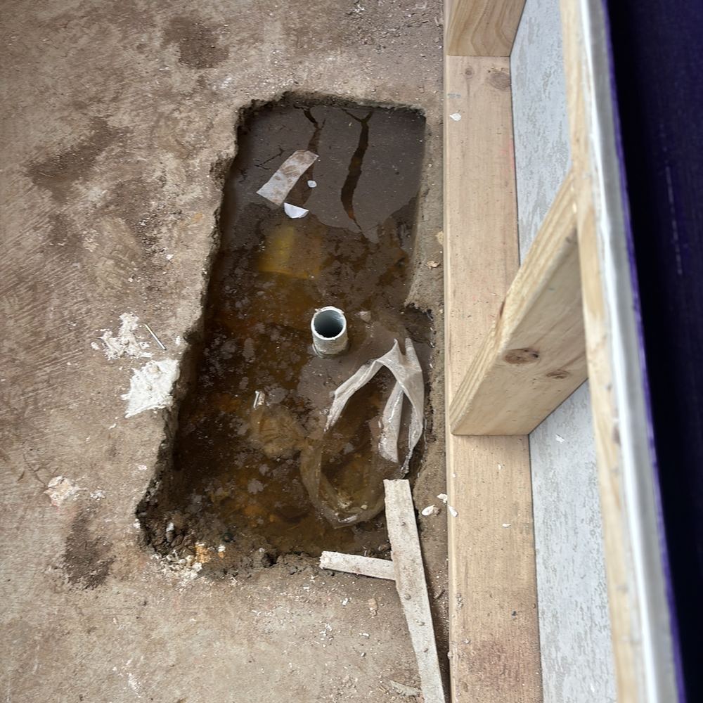 Water and debris in the bath hob cavity before the bath goes in, found during a waterproofing inspection in Maddingley