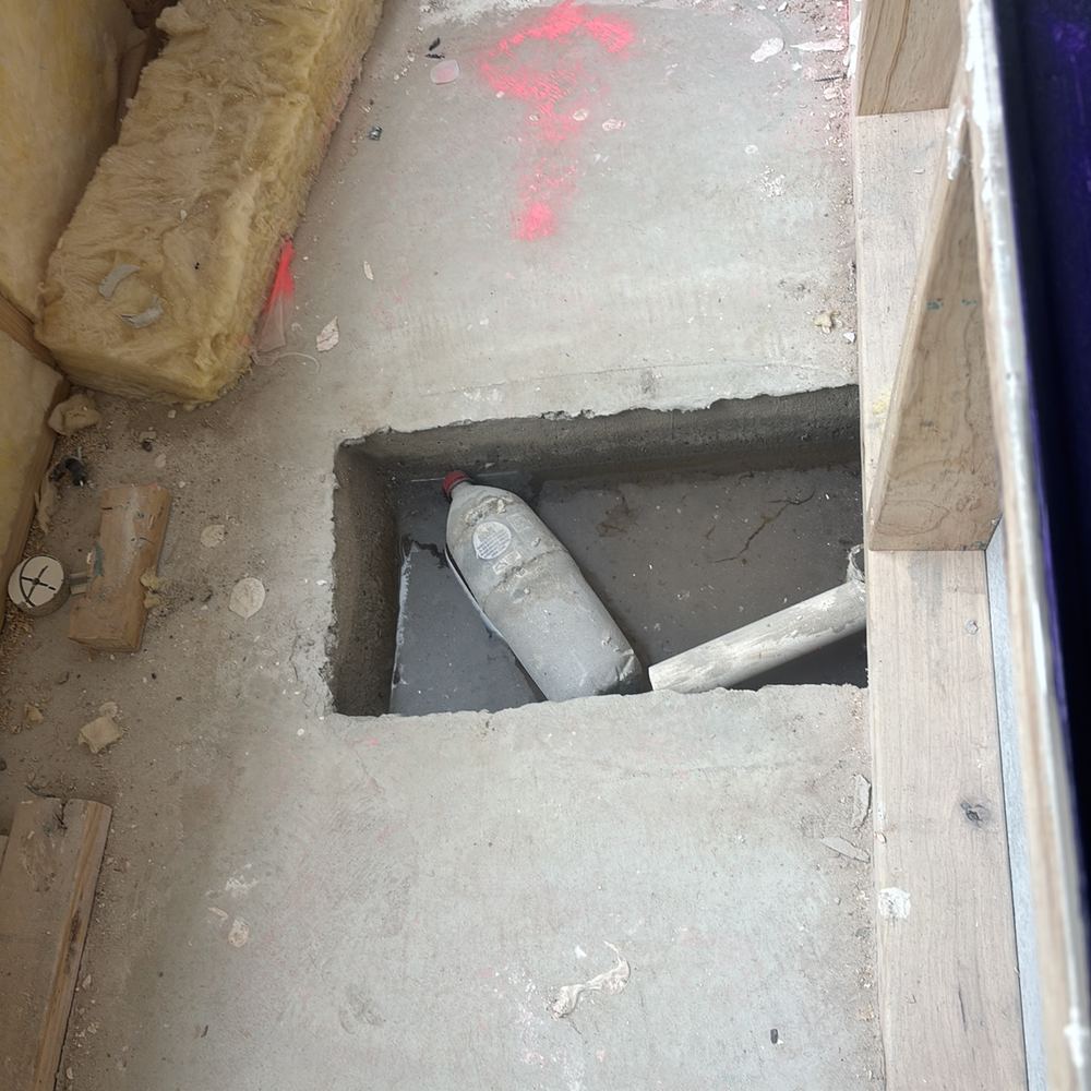 Bath waste recess needing to be cleaned out before fit-off, found during a waterproofing inspection in Maddingley